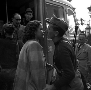 11. Un casto bacio alla partenza per il fronte, sotto lo sguardo del ministro della propaganda di Salò, Ferdinando Mezzasoma, 16 ottobre 1944 © Istituto Luce - Cinecittà